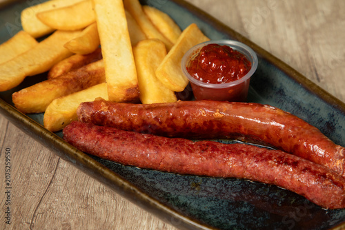 Bild auf Leinwand Assiette de viande avec des frites et une sauce rouge servie dans un plat