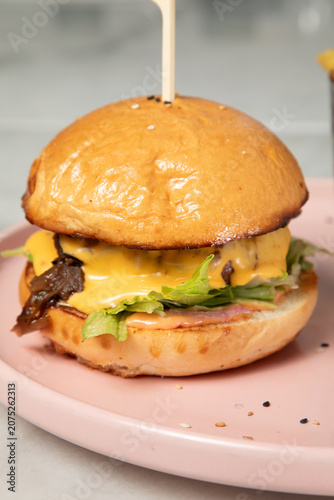 Dégustation d'un hamburger avec fromage et salade à l'heure du déjeuner