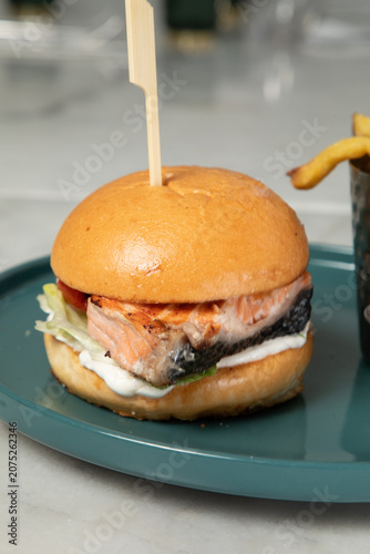 Déjeuner avec un hamburger au saumon sur une assiette verte