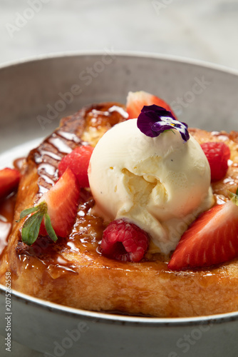 Pain perdu avec glace vanille, fraises et framboises servis dans un bol