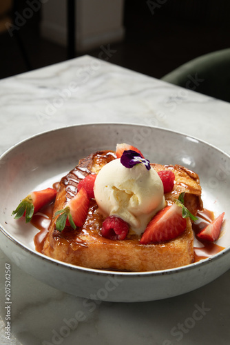 Pain perdu avec glace vanille et fruits frais sur une table en marbre