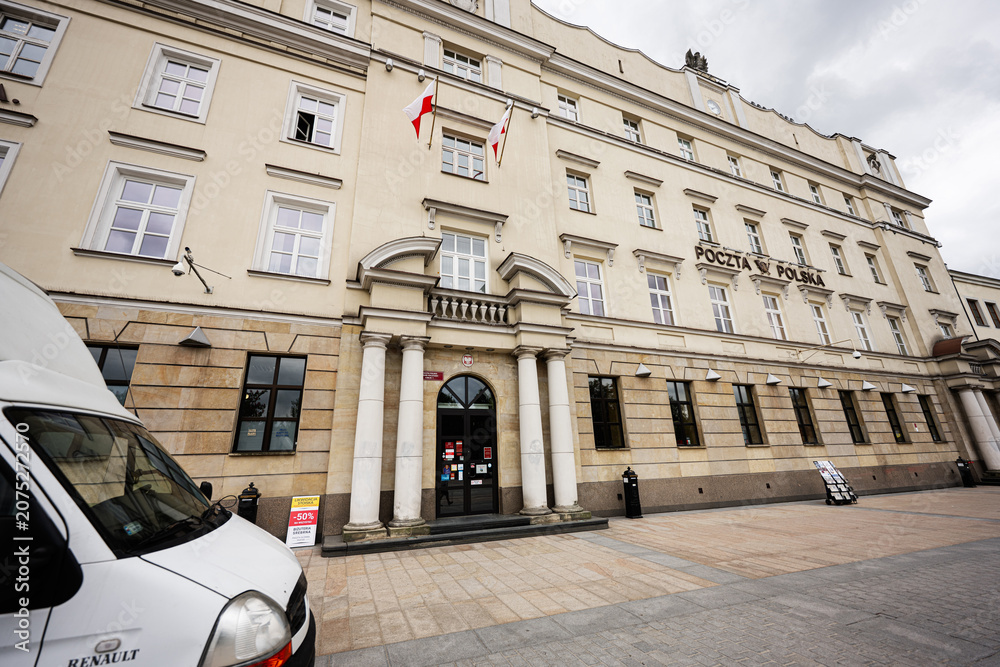 Obraz premium Historic Poczta Polska post office facade with Polish flags, delivery van and classical columns in Lublin, Poland