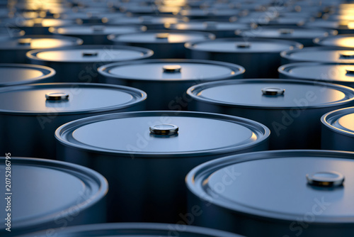 Industrial background with a repetitive pattern of metallic blue oil barrels neatly arranged in rows with soft golden reflection on tops creating a depth of field effect