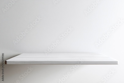 Empty white wooden shelf on a light gray wall