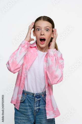Obraz na płótnie Shocked teenage girl with wide eyes and open mouth expressing surprise, amazement and disbelief
