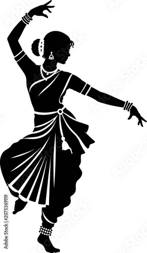 A woman performs traditional Indian dance in a studio with her arms raised.