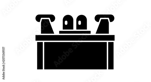 Black silhouette icon of a bathroom sink vanity with faucets.