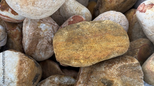 Canvas Print Warm golden river stones texture, yellow and terracotta sea pebbles background,