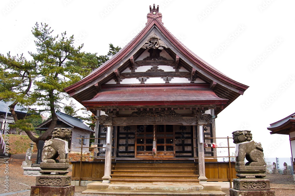 Fototapeta premium Traditional main hall of Gikeiji Temple with stone Komainu guardian statues in Sotogahama Aomori Japan