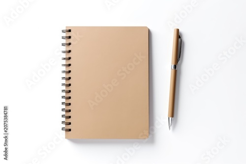 Spiral notebook with blank brown cover and matching pen on white background