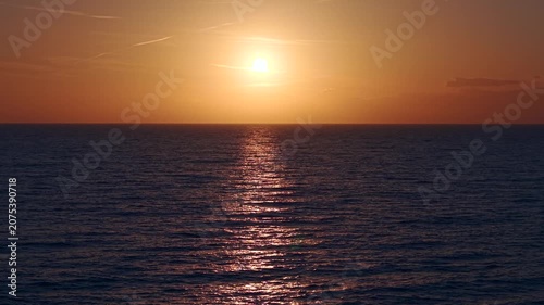 A breathtaking panoramic view of a dramatic golden sunset over the Mediterranean Sea in Agropoli, Cilento coast. The sky is filled with vibrant hues of orange, pink, yellow, and blue clouds, while the