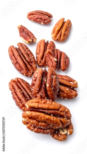 A close-up photo of a pile of brown nuts with visible ridges and shadows on a white background