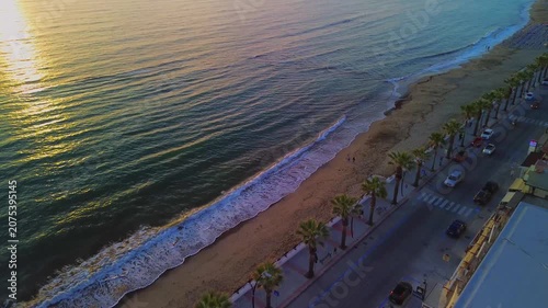 Aerial photography in 4K format – aerial view (ultra-high resolution) of sunset or sunrise on the seashore. Reflection in the water. Beautiful summer seascape of the Mediterranean Sea. Background 