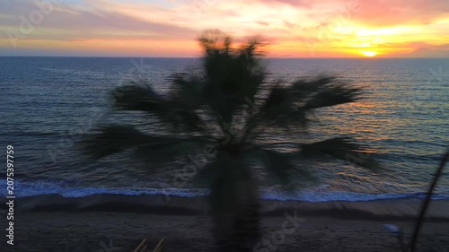A breathtaking panoramic view of a dramatic golden sunset over the Mediterranean Sea in Agropoli, Cilento coast. The sky is filled with vibrant hues of orange, pink, yellow, and blue clouds, while the