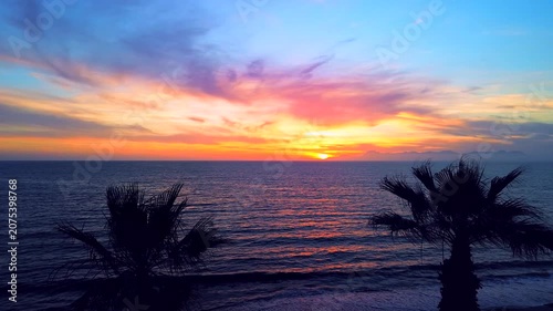 A breathtaking panoramic view of a dramatic golden sunset over the Mediterranean Sea in Agropoli, Cilento coast. The sky is filled with vibrant hues of orange, pink, yellow, and blue clouds, while the