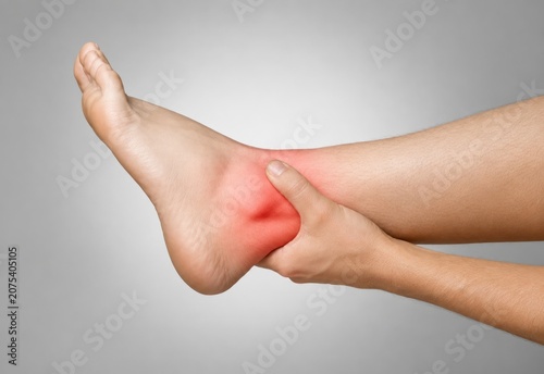 Man Suffering from Ankle Pain While Holding Injured Foot, Sports Injury, Rehabilitation and Medical Concept