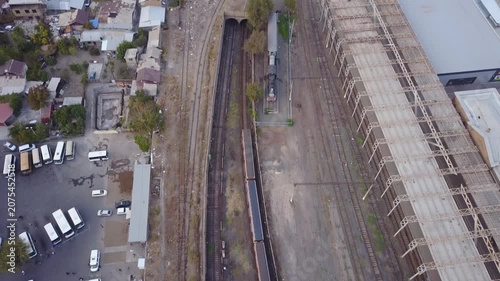 Aerial view of a train moving on the tracks in Yerevan, Armenia. The drone footage captures the railway system, surrounding buildings, and the urban landscape from a height.

