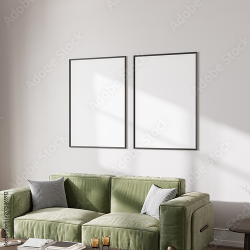 Two blank poster frames mockup on neutral living room wall above green sofa, sunlight, 3d render