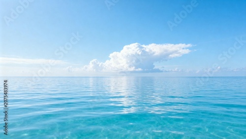 Calm ocean with white cloud in blue sky