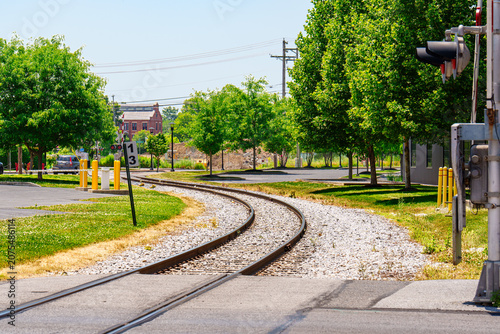 Curving train tracks lined with trees on a sunny day