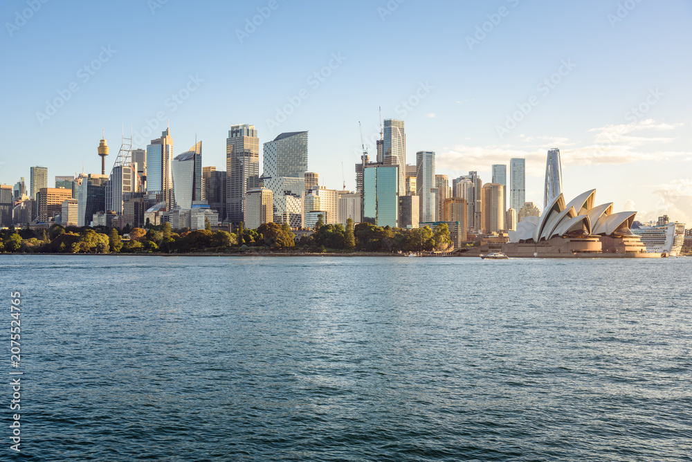 Obraz premium Sydney, Australia - May 01, 2026: Central Business District skyline and Opera House under clear sky at sunset in autumn.