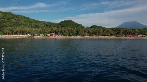 Aerial View of Virgin Beach with Palm Forest, Traditional Boats, Ocean Waves and Mount Agung in Bali