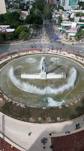 Guadalajara, Mexico - January 25 2026: Static drone view of Minerva Glorieta, Guadalajara. Iconic fountain, majestic statue, active water, people, cyclists, vibrant urban scene.