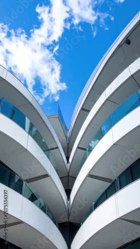 Modern architecture with curved white facade and blue-sky background