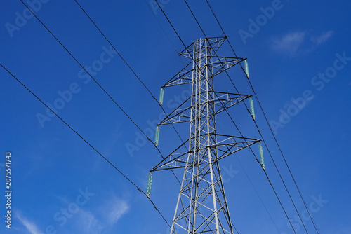 Cuadro en lienzo Large high-voltage pylons and transmission lines supply electricity to the capital city under a clear blue sky