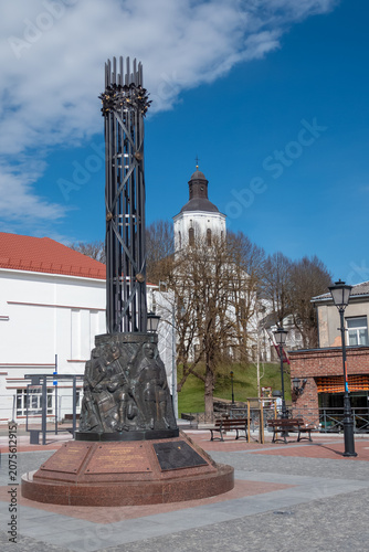 Metal monument in town square with church