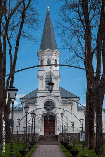 Path through trees to a white church