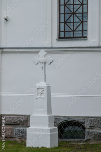 White memorial cross beside church wall
