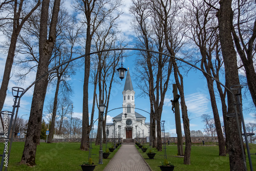 Path through trees to a white church