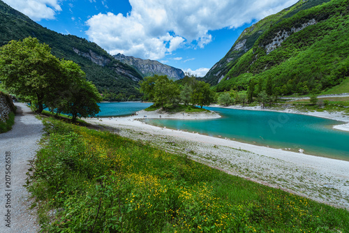 Bild auf Leinwand The view of Lake Tenno, a splendid alpine lake nestled between mountains and woo