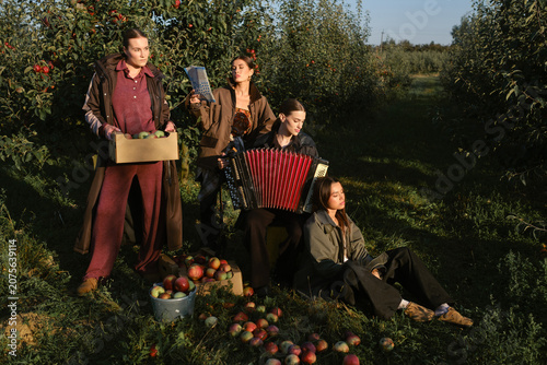 Fotografie Four stylish girls have fun celebrating the apple harvest at sunset
