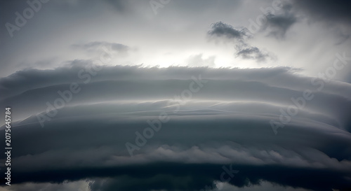 Dramatic Sky with Dark Clouds and Sunlight Breaking Through Over Landscape