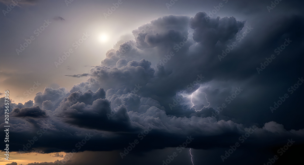 Obraz premium Dramatic Storm Clouds Over Calm Water at Sunset with Silhouetted Birds