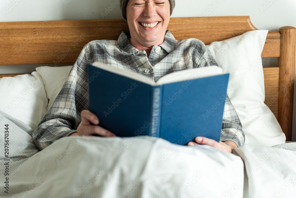 Fototapeta premium Relaxed reading in cozy bed