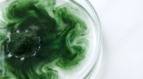 Spirulina Powder Swirls: A close-up shot captures the mesmerizing swirls of green spirulina powder dissolving in water, showcasing its vibrant color and fine texture.