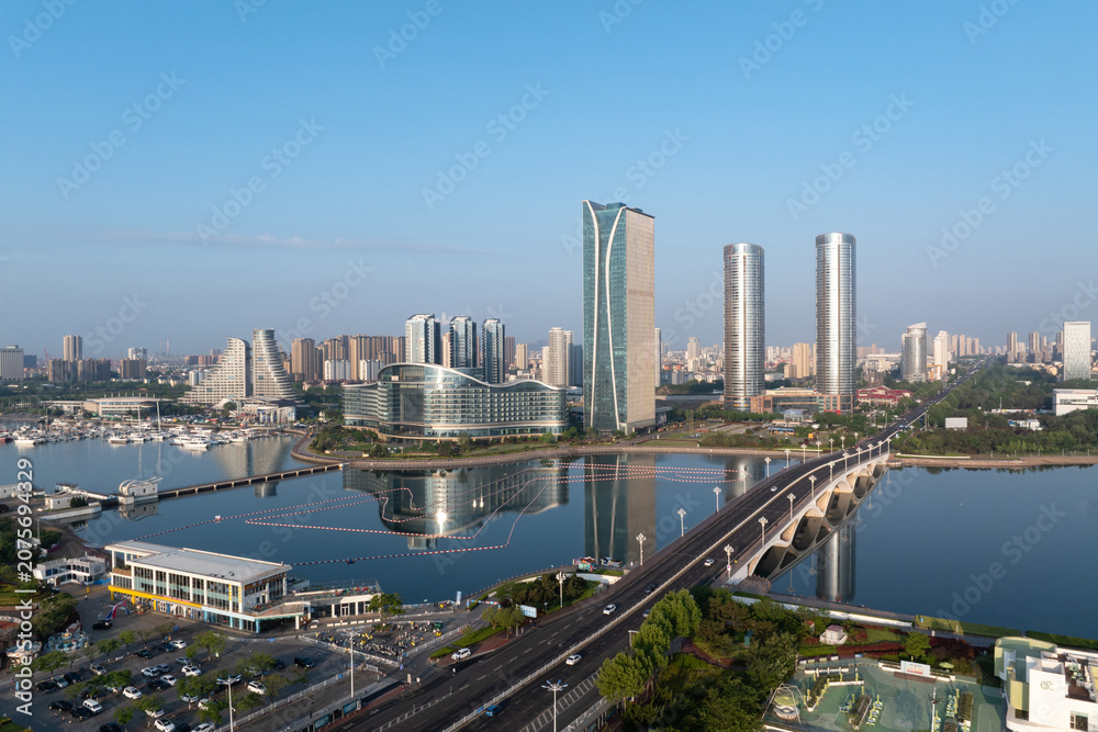 Fototapeta premium Xiamen Wuyuan Bay modern architecture complex and sea-crossing bridge under clear morning sky