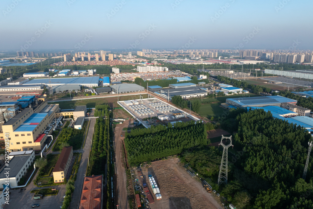 Fototapeta premium Aerial view of industrial park featuring factories greenery power grid infrastructure and layout planning
