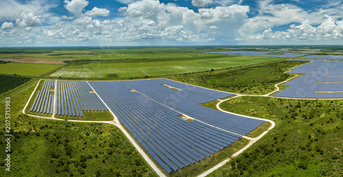Obraz na płótnie Aerial view of large sustainable electrical power plant with rows of solar photovoltaic panels for producing clean electric energy