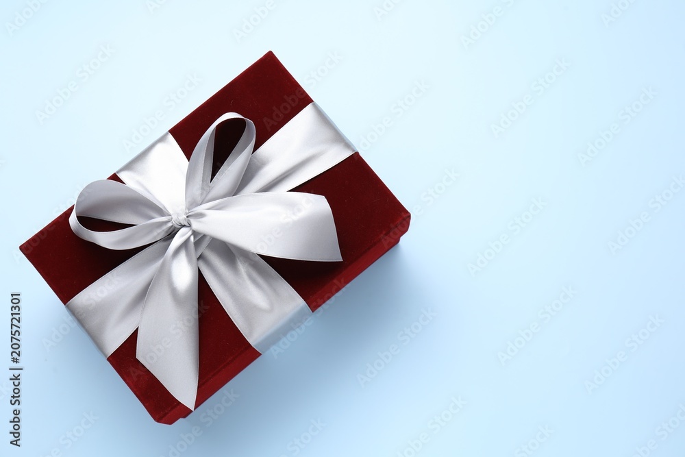 Fototapeta premium Beautiful velvet gift box on light blue background, top view. Space for text