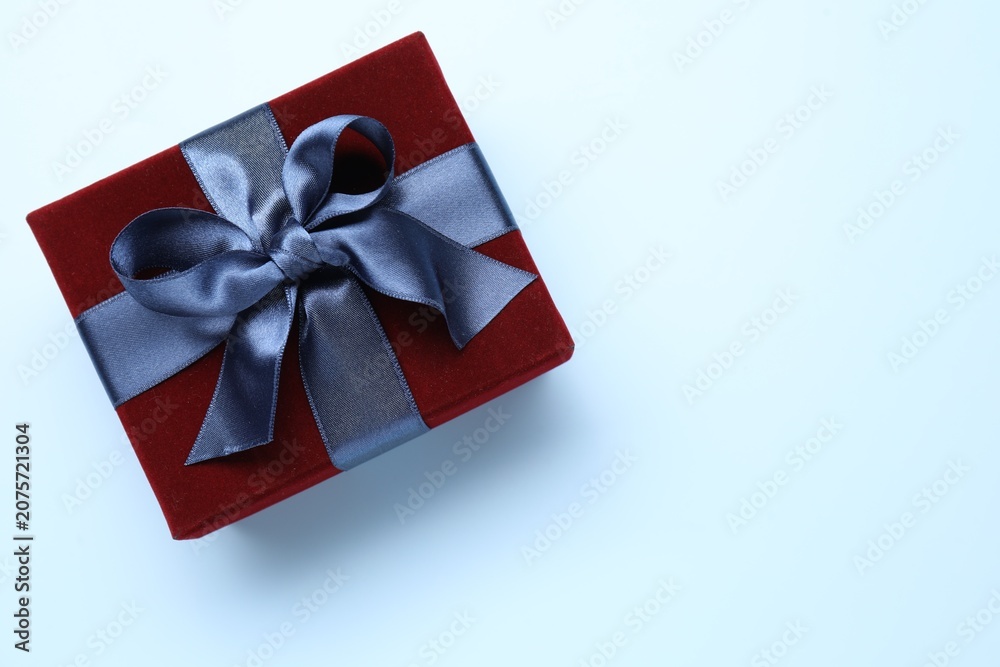 Fototapeta premium Beautiful velvet gift box on light blue background, top view. Space for text