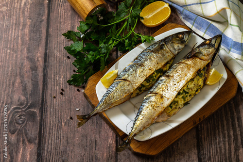 Grilled baked mackerel in ginger mustard honey sauce stuffed with vegetables and cheese on a rustic tabletop. Copy space.
