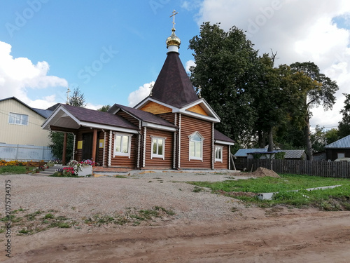 Cuadro en lienzo wooden orthodox church with golden dome stands on dirt site