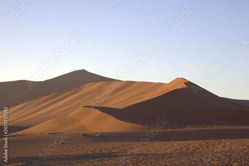 Massive Red Sand Dunes at Sossusvlei Namib Desert Namibia at Golden Hour Sunrise with Clear Blue Sky