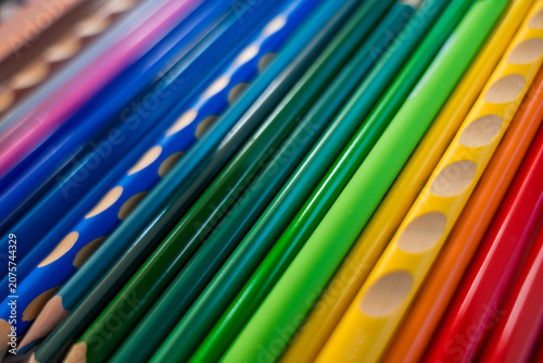 Принти на полотні A close-up of colorful pencils arranged in a neat row on a dark background, showcasing a variety of bright colors