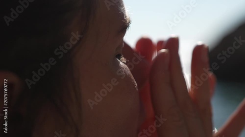 Sunscreen skincare beach woman applying sun protection cream on her face outdoors near the ocean during a sunny summer vacation day