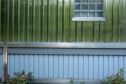 Obraz na płótnie Corrugated metal siding and glass block window with roses